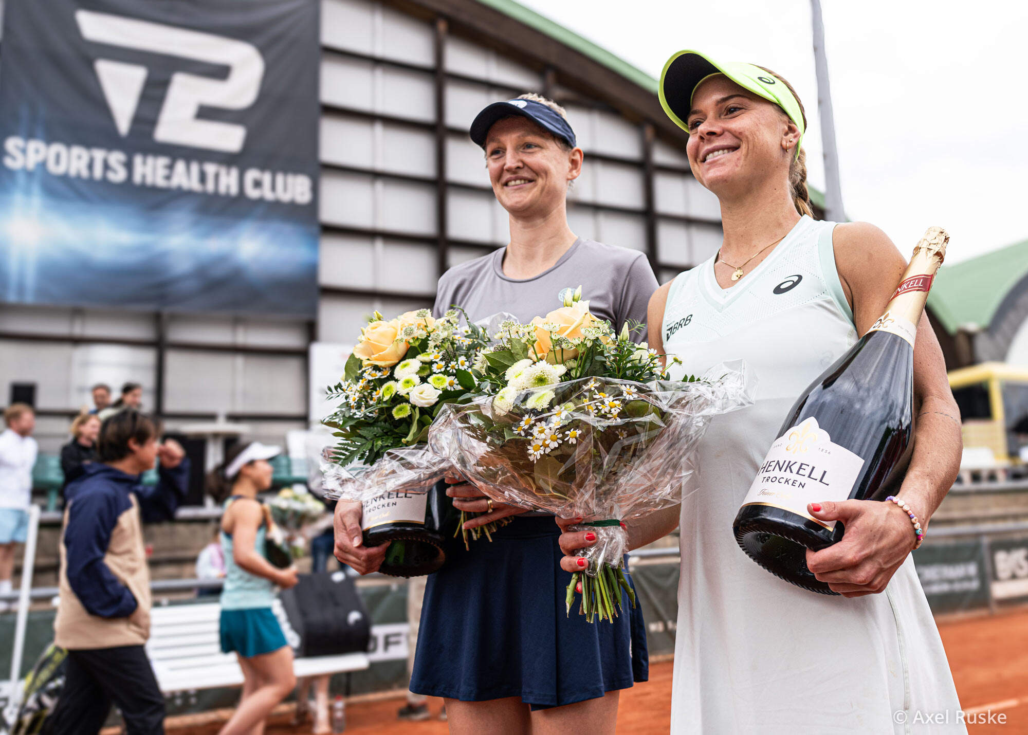 Doppelsiegerinnen mit Blumen und Sekt