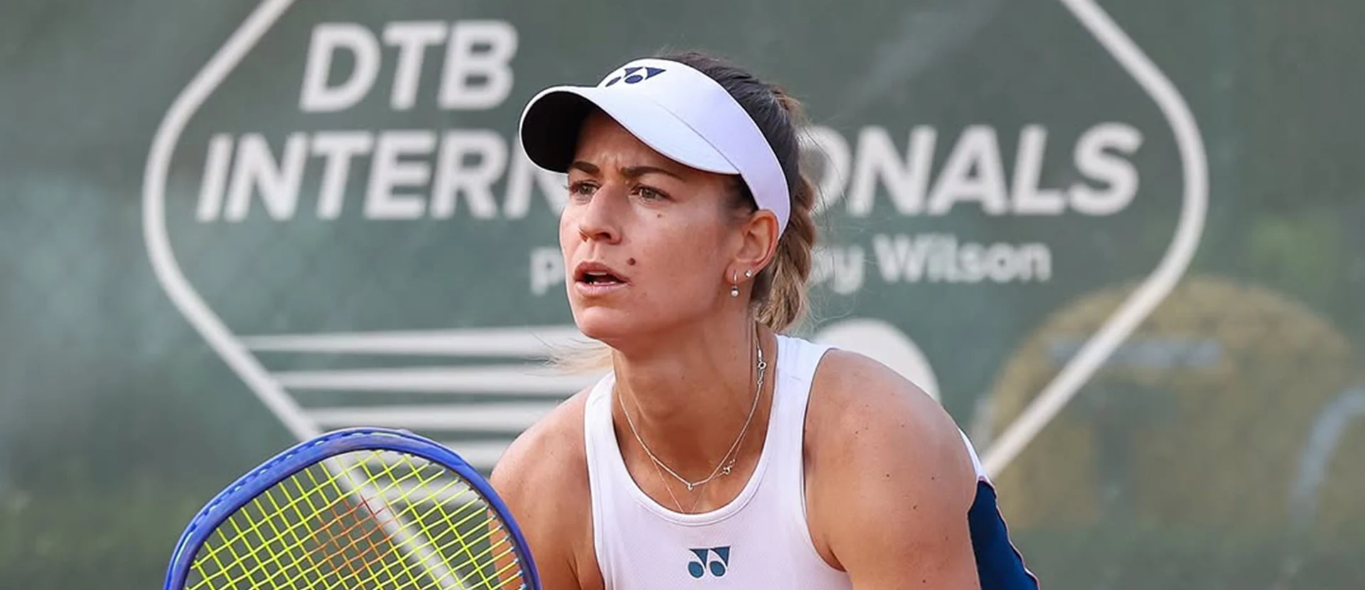 Spielerin in weißer Kleidung in Spielhaltung